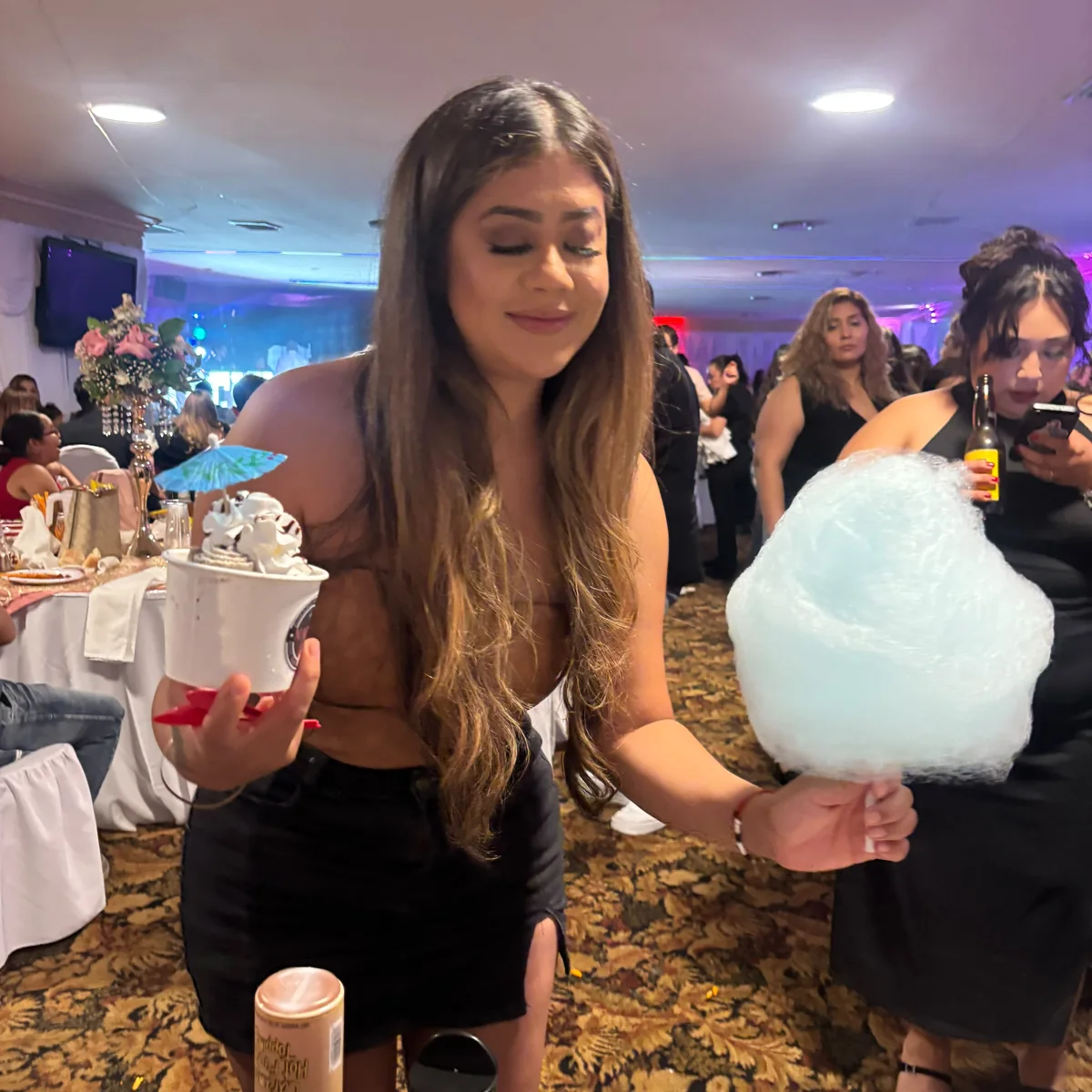 Guest holding cotton candy and Numero Uno rolled ice cream